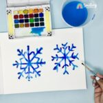sketchbook with two painted blue snowflakes